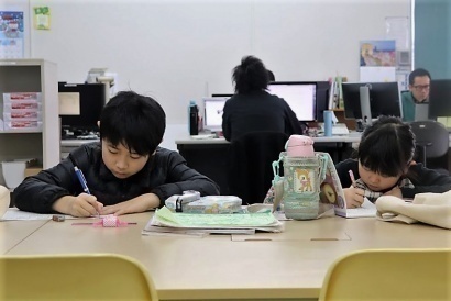 ゴーフィールドの社内で宿題をする子ども